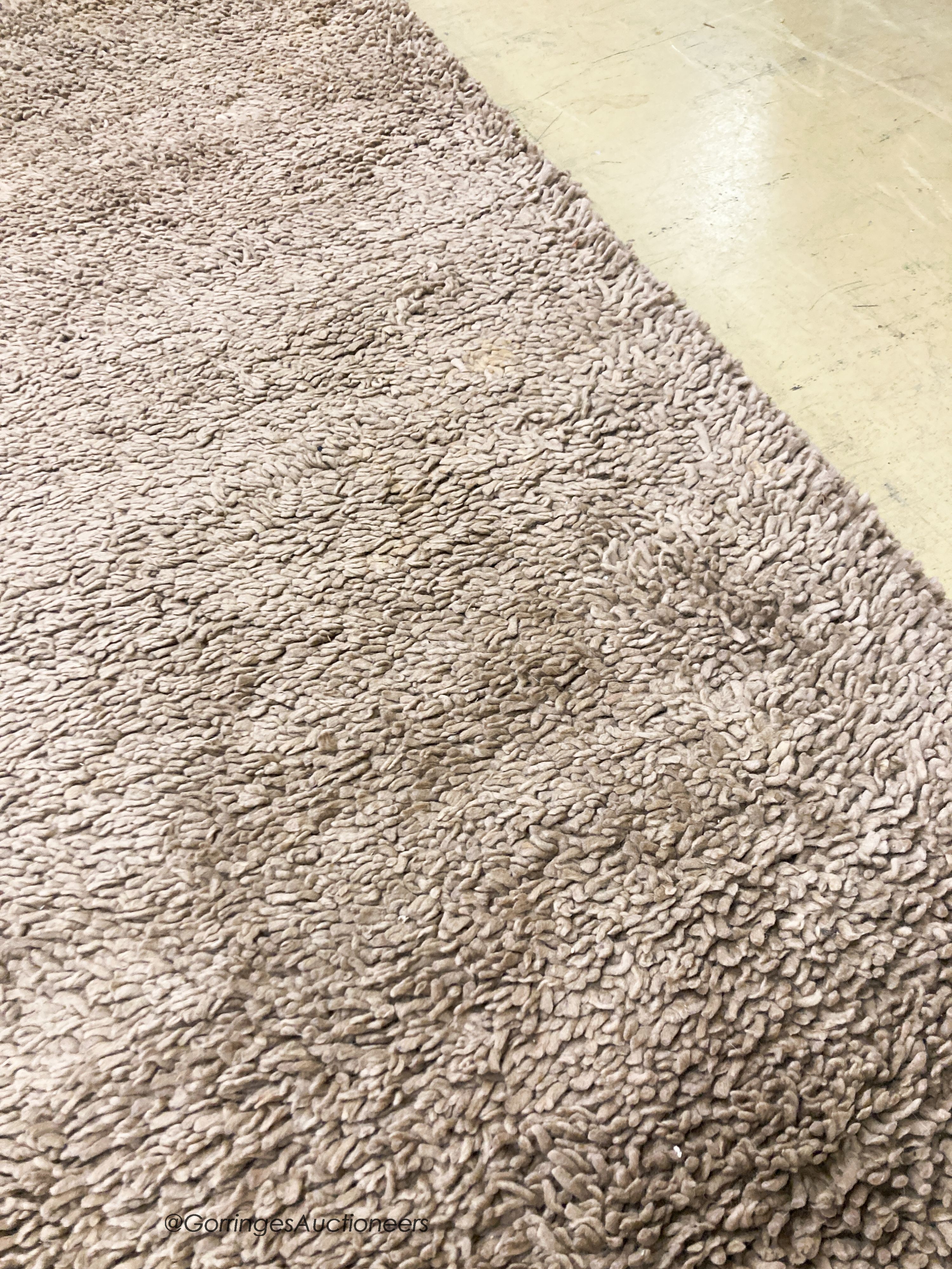 A contemporary brown shag pile carpet, 300 x 200cm